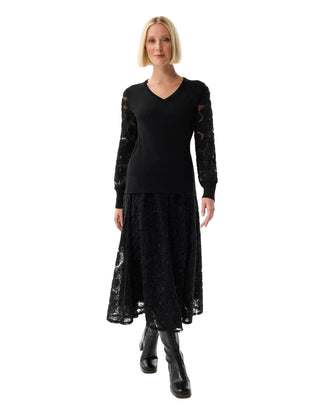 Woman wearing a black dress with lace sleeves on a white background