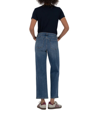 Person wearing blue jeans and a navy shirt on a beige background