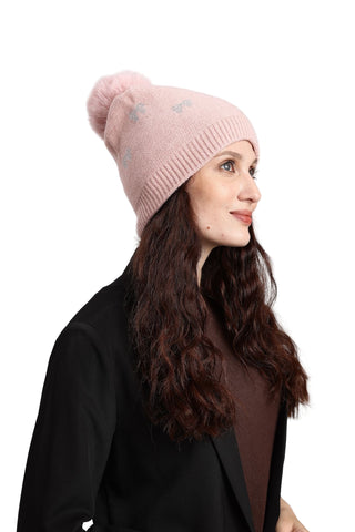 Woman wearing a pink beanie with star patterns on a light gray background