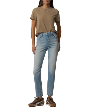 Person wearing a brown t-shirt and light blue jeans on a beige background