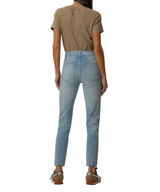 Person wearing light blue jeans and a brown shirt on a plain background
