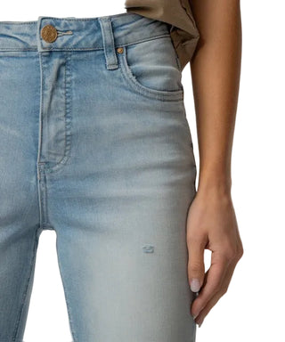 Close-up of light blue jeans with a beige background