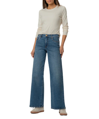 Person wearing blue jeans and a light-colored top on a white background