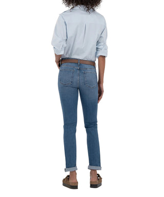 Person wearing blue jeans and a light blue shirt on a beige background