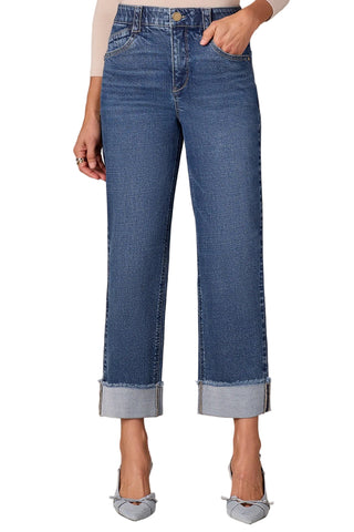 Blue jeans worn by a person on a beige background