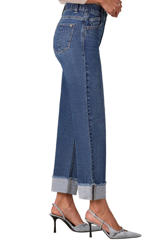 Blue jeans with a slit on a beige background