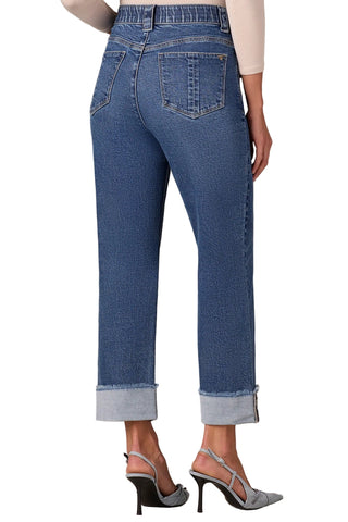 Blue jeans worn by a person on a beige background