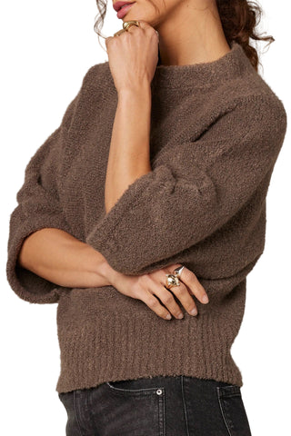 Brown sweater worn by a person on a neutral background