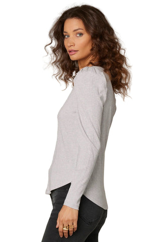 Woman wearing a light gray sweater against a beige background