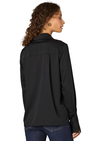 Person wearing a black jacket on a plain background