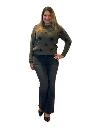 Woman posing in front of a branded backdrop with 'Anne's on the Avenue' logo.