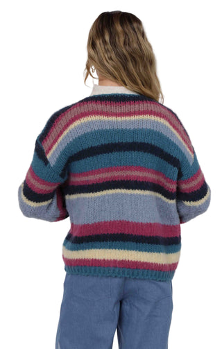 Person wearing a colorful striped sweater on a white background