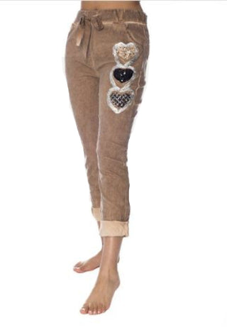Brown pants with decorative heart patches on a white background