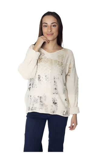 Woman wearing a textured beige sweater and dark pants on a white background