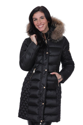 Woman wearing a black puffer coat with a fur-lined hood on a white background