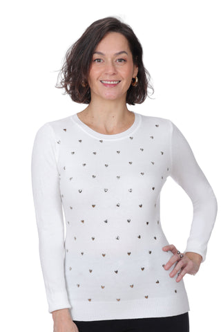 Woman wearing a white sweater with small black heart patterns on a white background