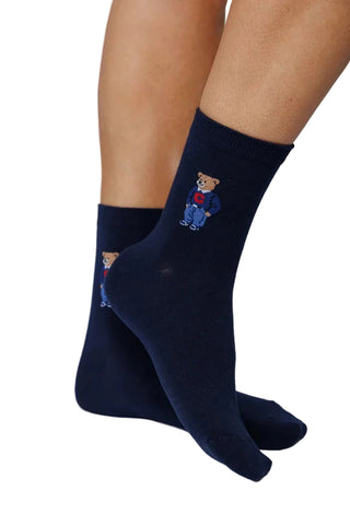 Navy blue socks with teddy bear design worn by a person on a light gray background