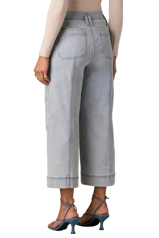 Person wearing light gray wide-leg jeans on a beige background
