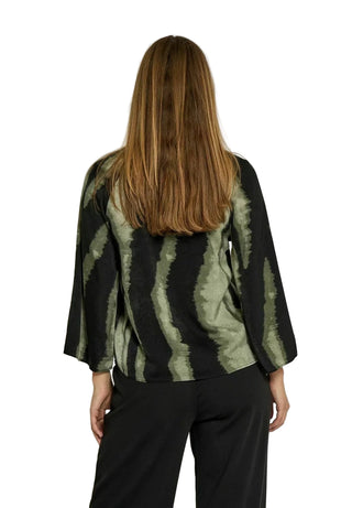 Person wearing a black and green patterned jacket on a white background