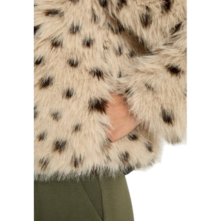 Close-up of a person wearing a fur coat with a spotted pattern on a white background