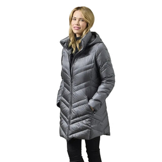 A woman wearing a mid-length gray quilted puffer coat with a high collar, standing against a plain gray studio background.