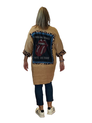 Person wearing a beige jacket with a Rolling Stones logo on the back against a white background