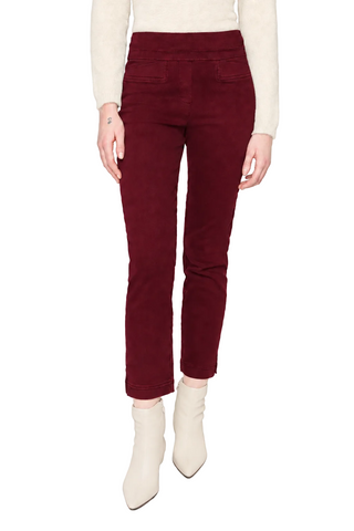 A model is shown from the waist down wearing high-waisted, straight-leg corduroy pants in deep burgundy, paired with cream-colored ankle boots and a cream long-sleeve top, against a light gray studio background.