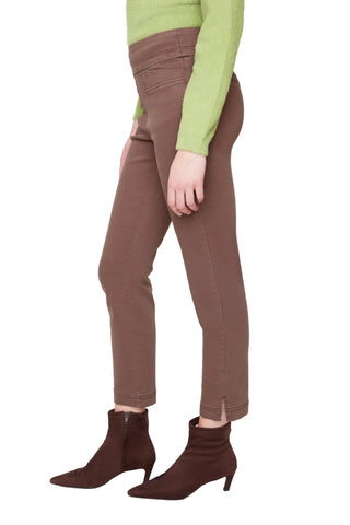 Person wearing brown pants and brown ankle boots on a white background