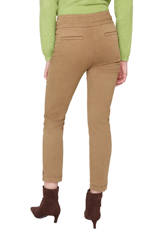 A model shown from the back wearing tan cropped pants, a light green sweater, and brown ankle boots against a light gray studio background.