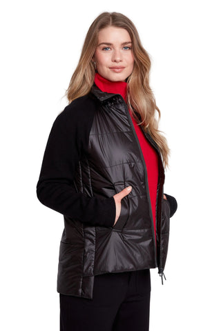 Woman wearing a black puffer vest over a red shirt on a white background