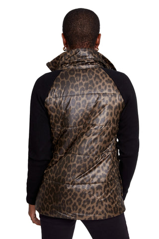 Person wearing a leopard print vest over a black long-sleeve shirt on a white background