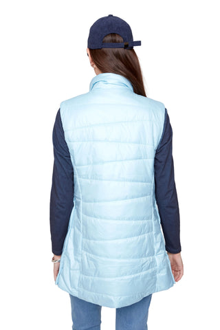 Person wearing a light blue puffer vest over a dark long-sleeve shirt on a white background