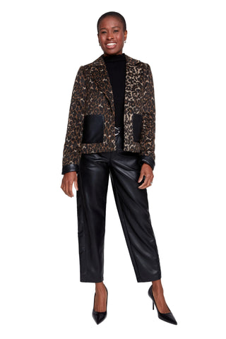 Person wearing a leopard print jacket and black pants on a white background