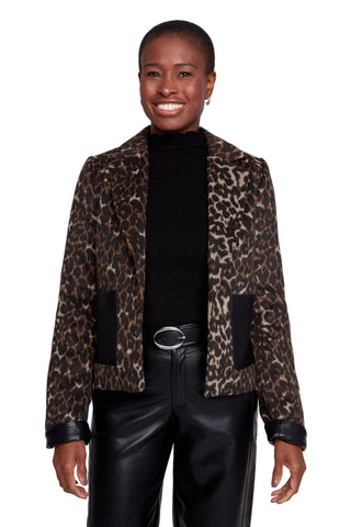 Woman wearing a leopard print jacket over a black top and pants on a white background