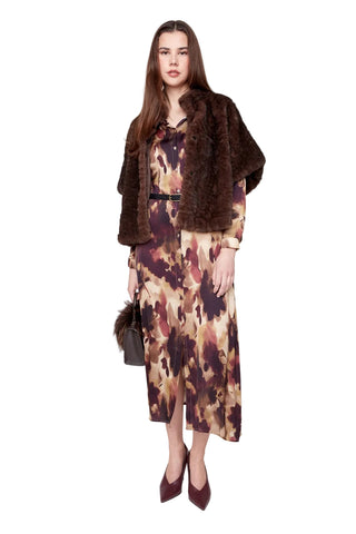 Woman wearing a patterned dress with a fur coat on a white background