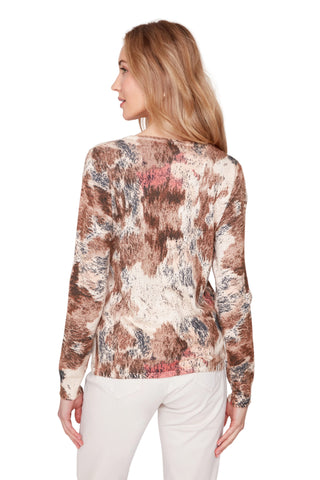 Woman wearing a long-sleeve, patterned top on a white background