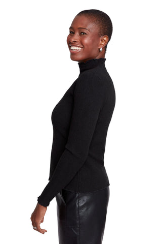 Woman wearing a black turtleneck sweater and leather pants on a white background