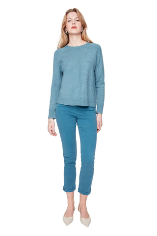 Woman wearing a blue sweater and pants on a white background
