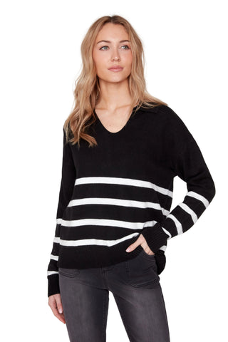 Woman wearing a black and white striped sweater against a plain background
