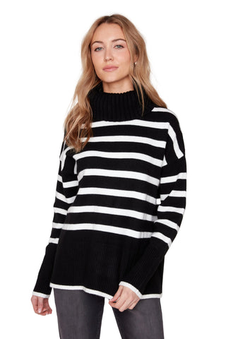Woman wearing a black and white striped sweater against a plain background