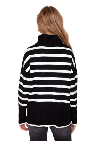 Person wearing a black and white striped sweater on a plain background