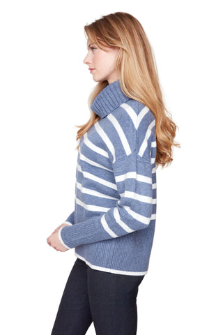 Woman wearing a blue and white striped sweater against a plain background