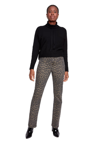 Person wearing a black turtleneck and leopard print pants on a white background