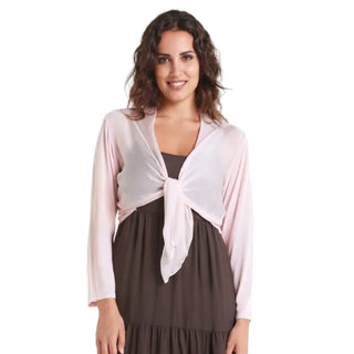 Woman wearing a pink cardigan over a brown dress on a white background