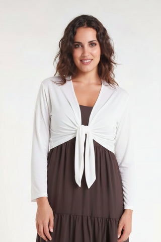 Woman wearing a pink cardigan over a brown dress on a white background