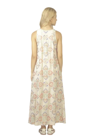 Woman wearing a sleeveless dress with a floral pattern on a plain background