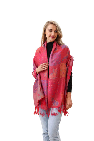 Woman wearing a red patterned scarf in a bright room with curtains and a plant.