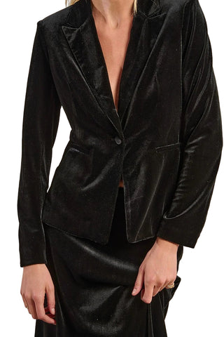 Black velvet blazer worn by a person on a beige background