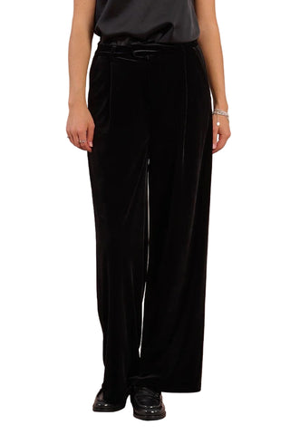 Person wearing black wide-leg pants against a plain background