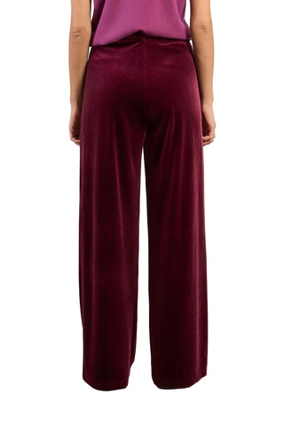 Maroon pants worn by a person on a plain background
